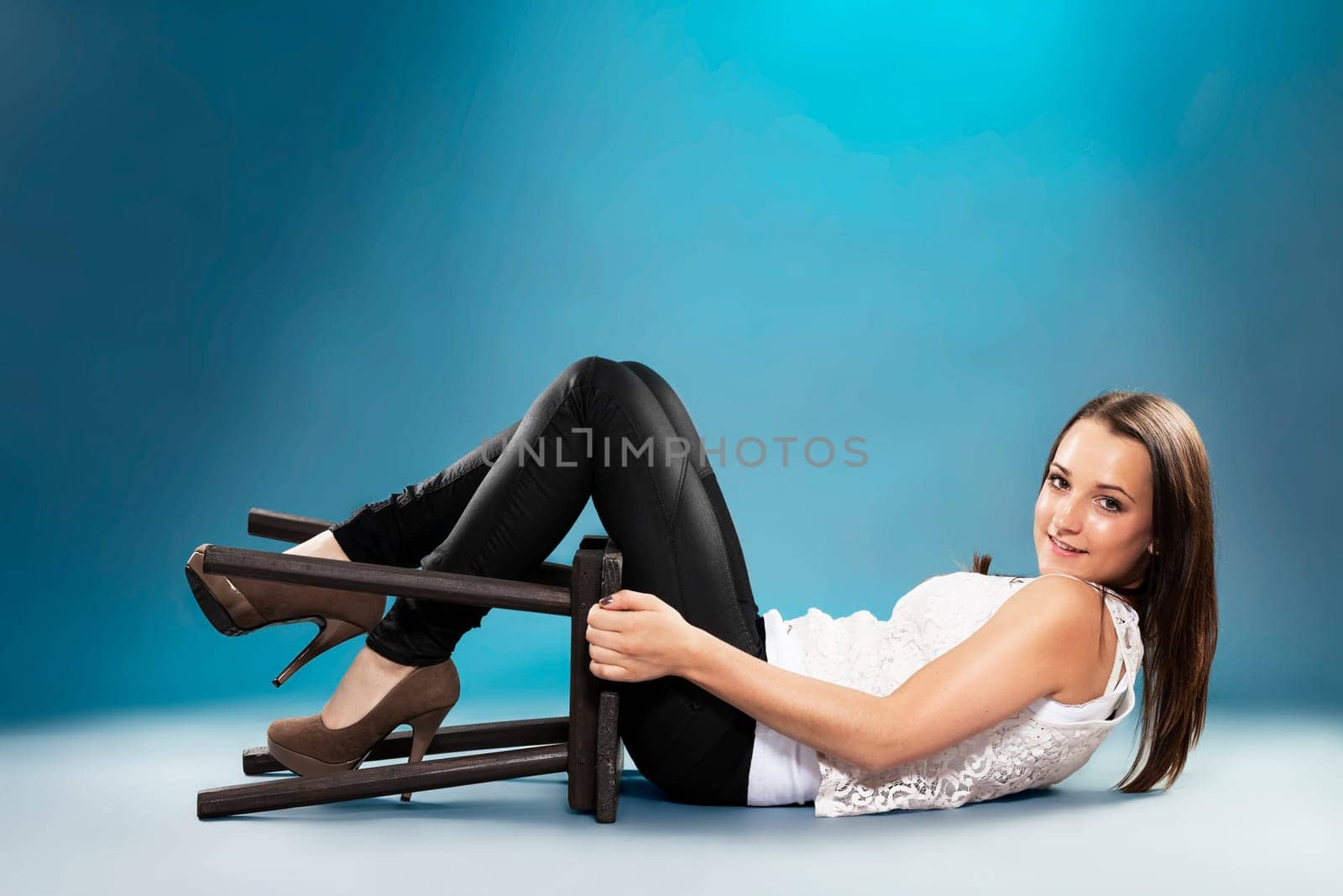 Female teenager lying on the floor with stool