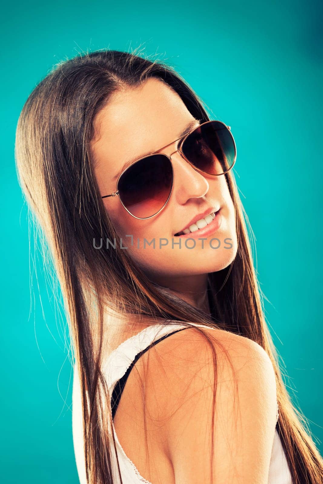 Pretty young girl in sunglasses looking over her shoulder