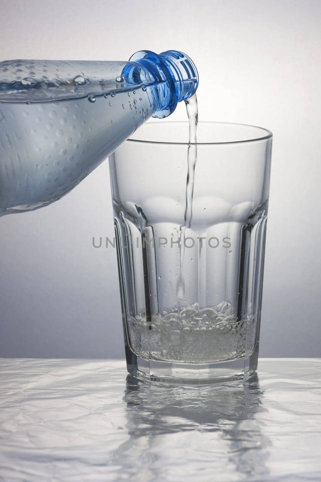 Pouring sparkling water into a caipirinha glass