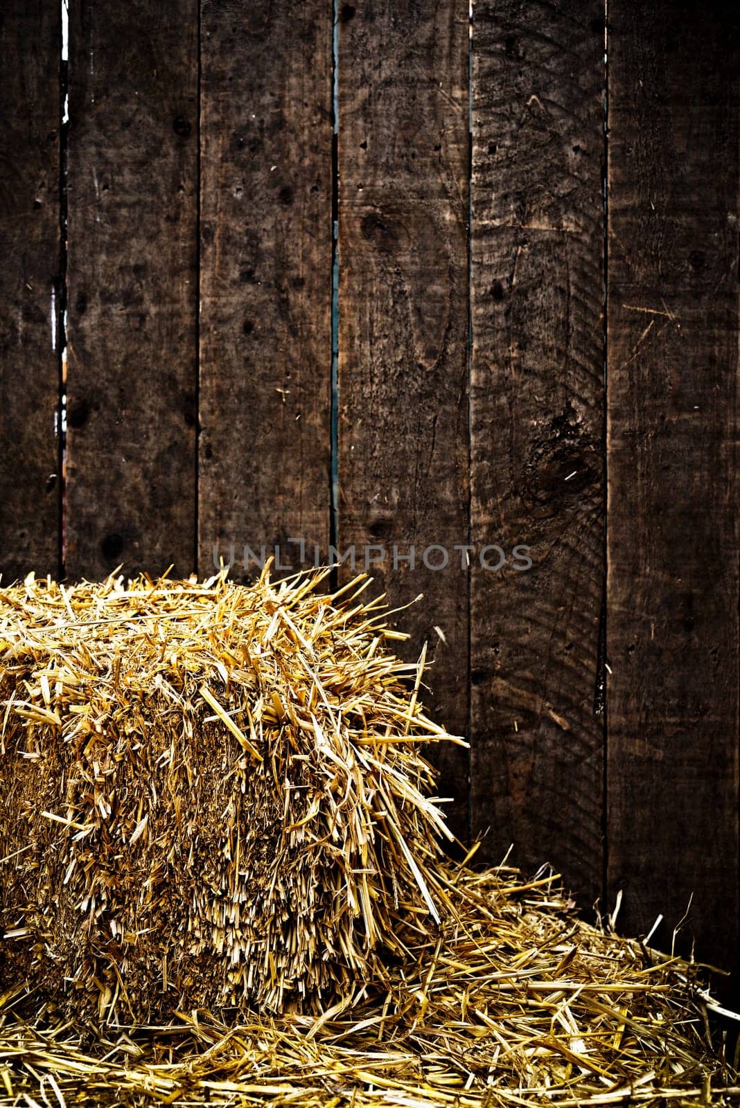 Bale of straw and dark wooden background with vignette