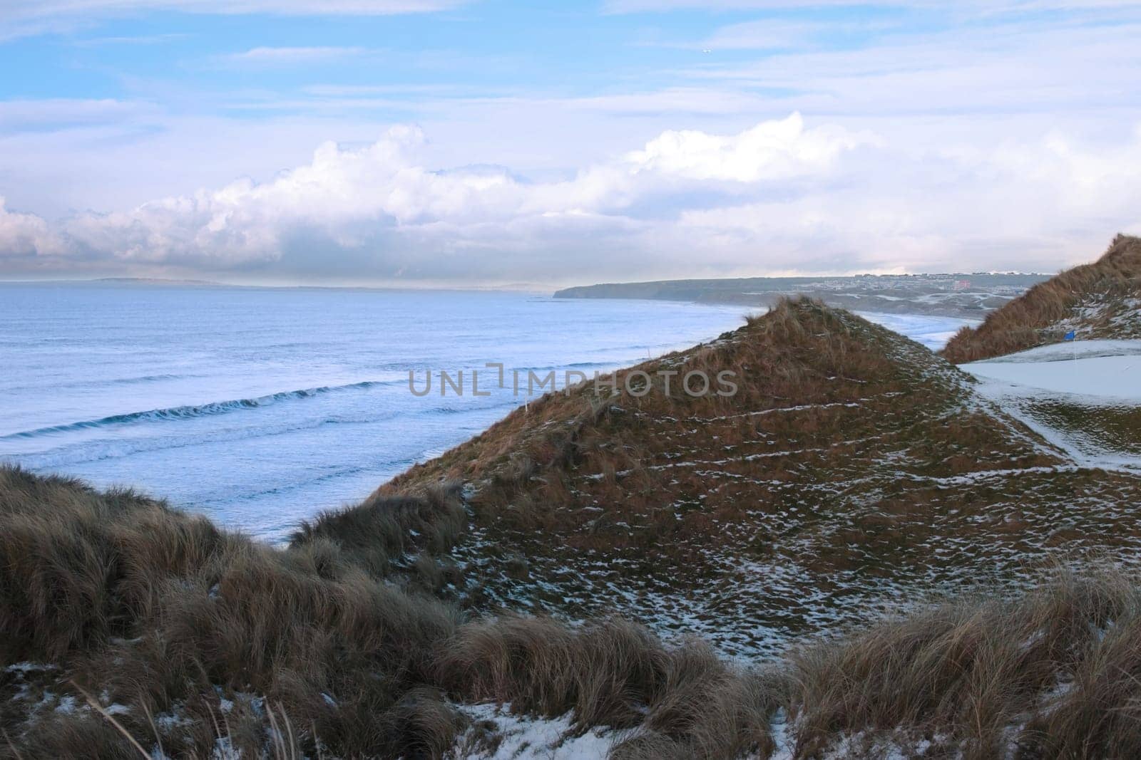 atlantic ocean beside a snow covered links golf course in ireland in snowy winter weather