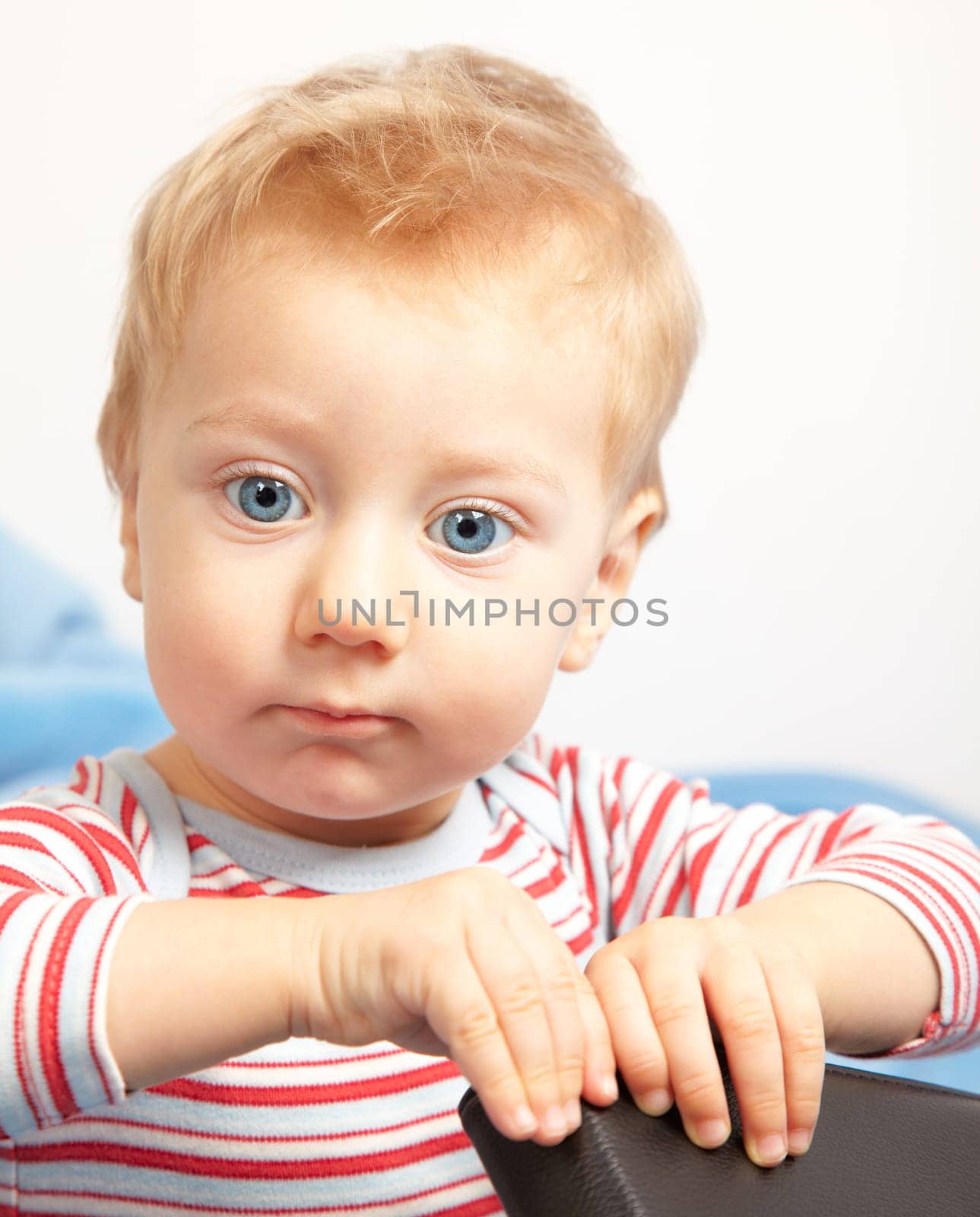 Portrait of a sad blond baby boy.