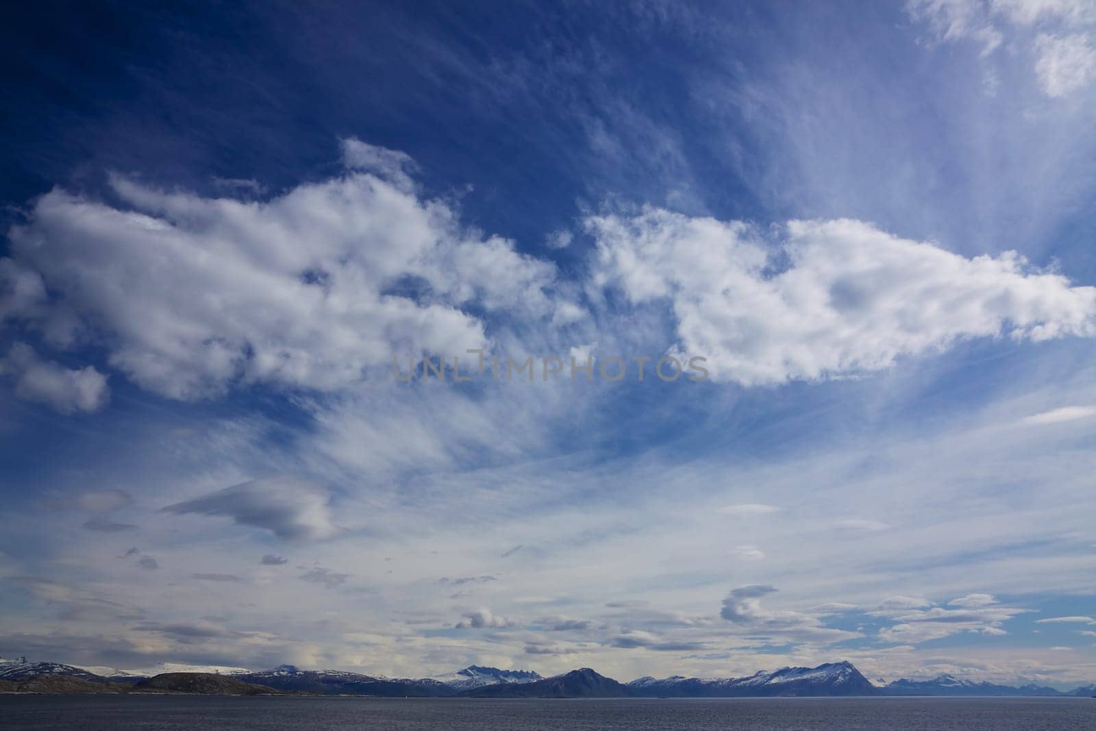 Scenic cloudscape with mountainous norwegian coastline around town Bodo