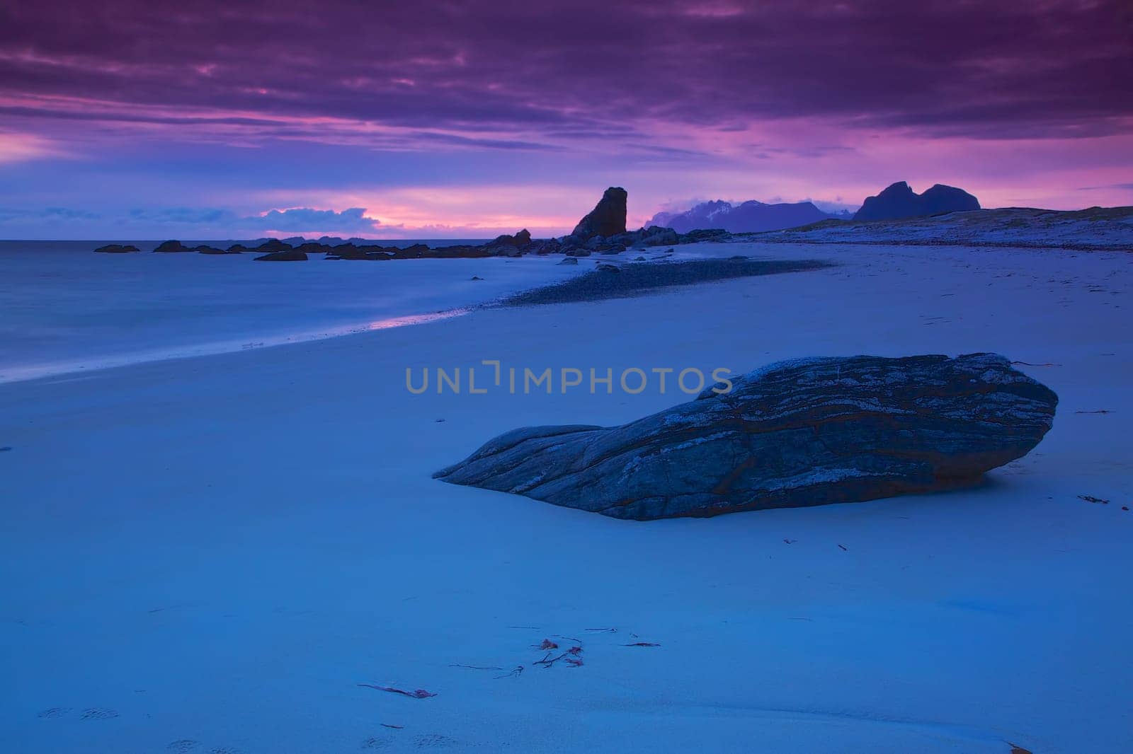 Scenic sandy beach lit by midnight sun on Lofoten islands in Norway