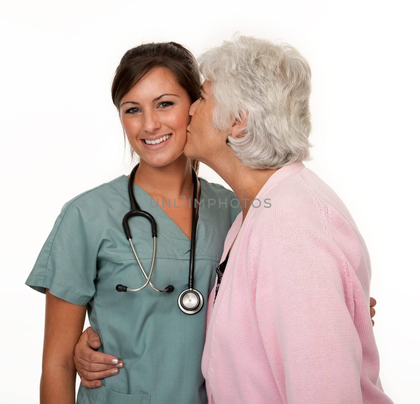 Studio photo of mature woman being affectionate with young nurse on white background.