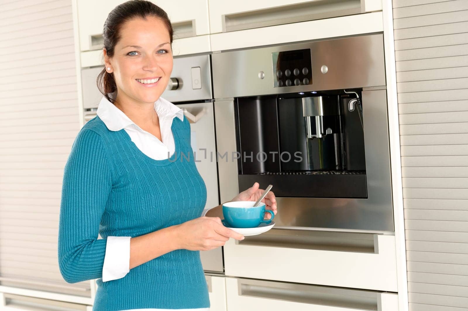 Smiling woman drinking cappuccino kitchen machine cup home interior