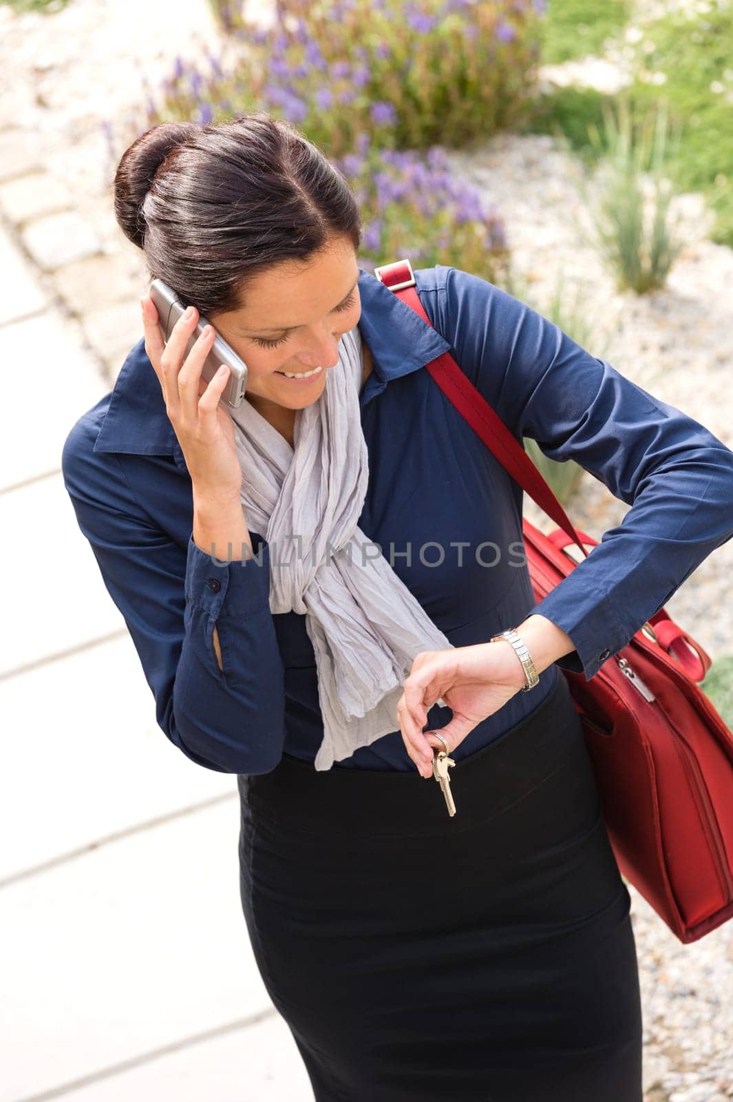 Woman calling rushing arriving home keys smart phone elegance business