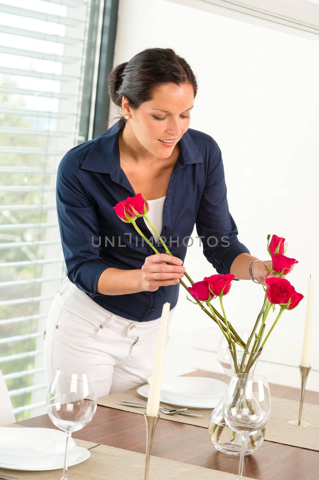 Young woman arranging flowers dinner table preparation