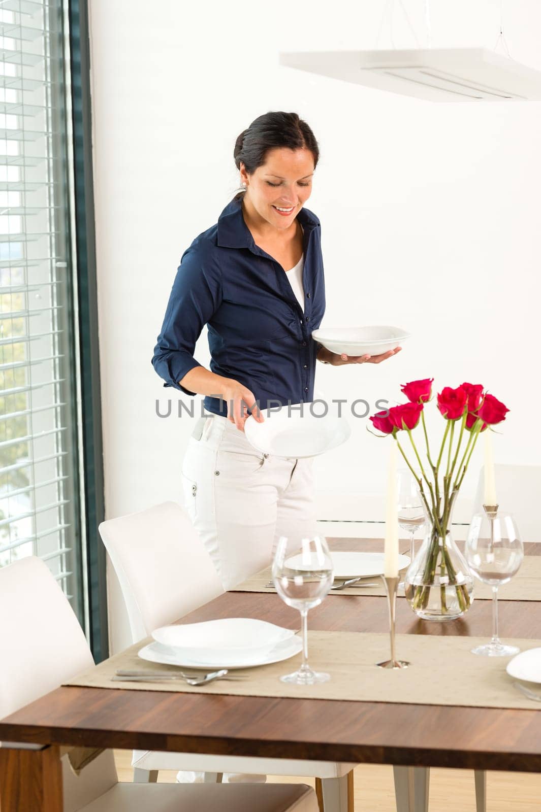 Pretty woman setting table dining room preparing plates