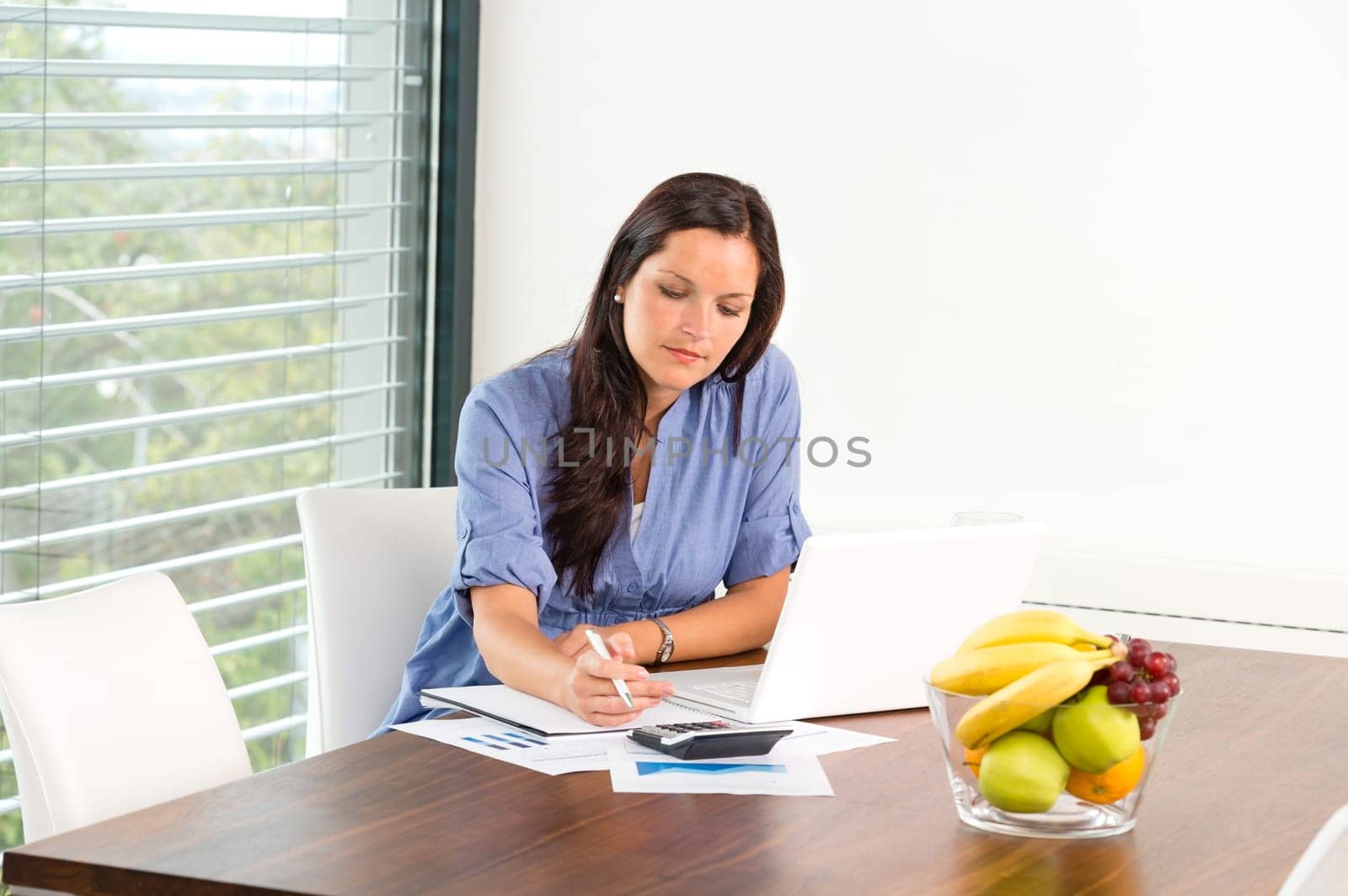 Student studying writing research examination living room laptop internet