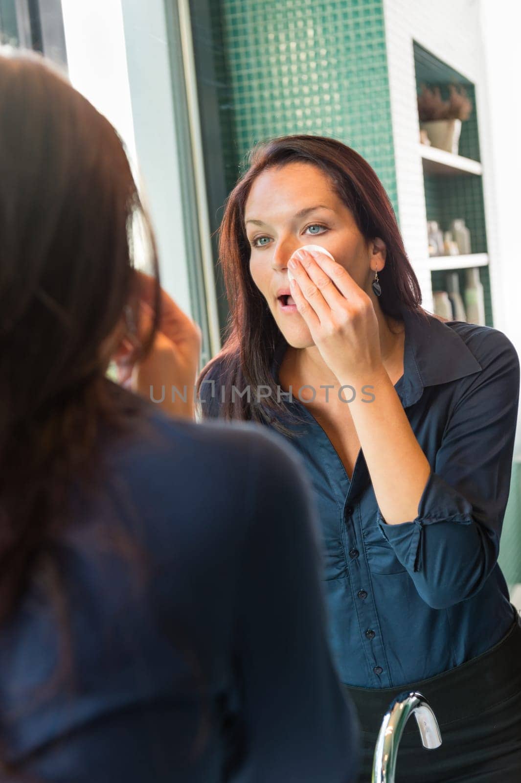 Woman removing make-up cleansing pads cleaning facial care bathroom