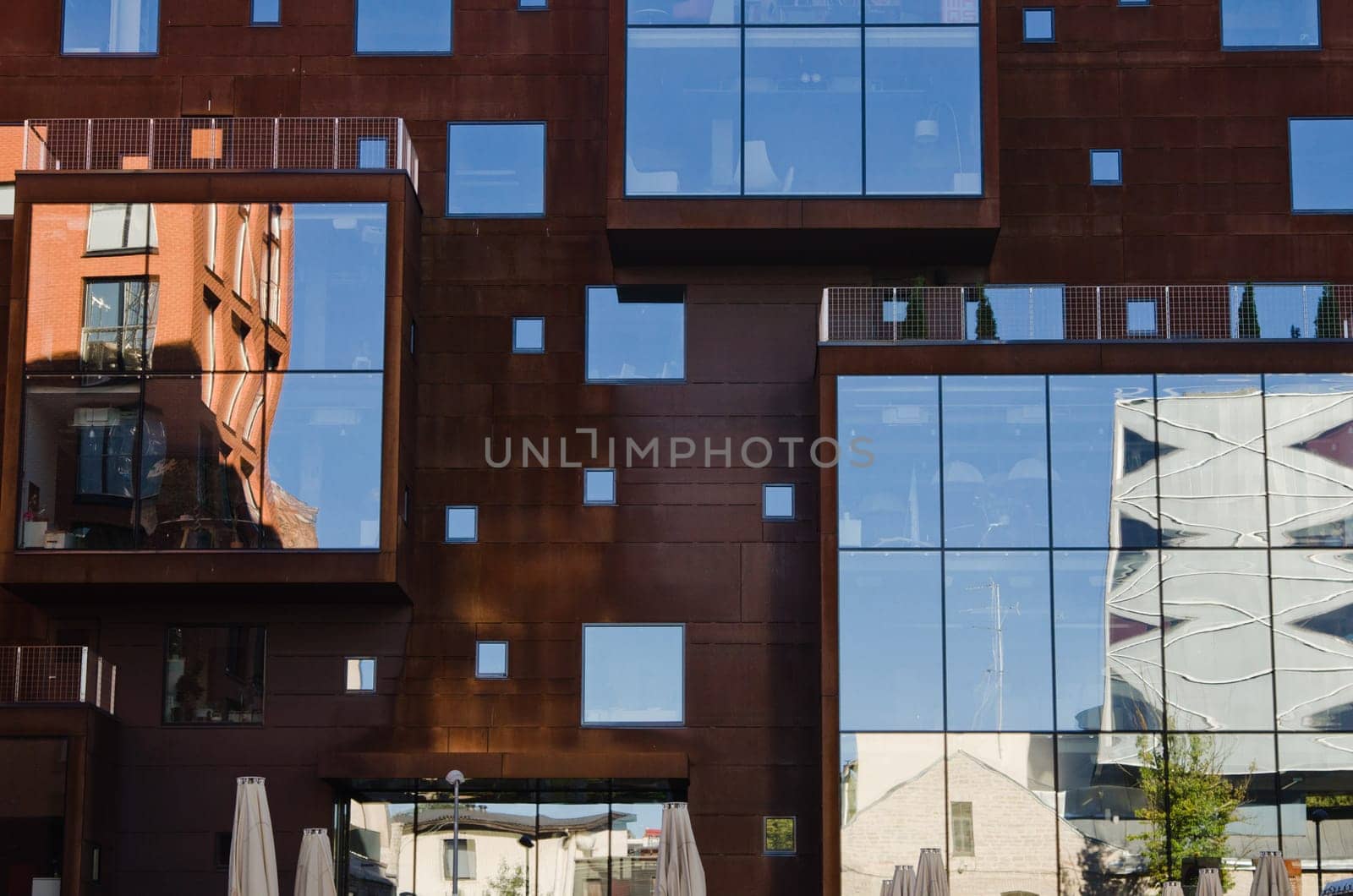 houses and blue sky reflected in windows of modern office building.