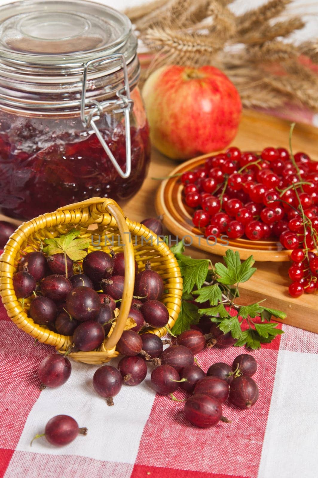 Jam with berries of red currant and gooseberry on the table
