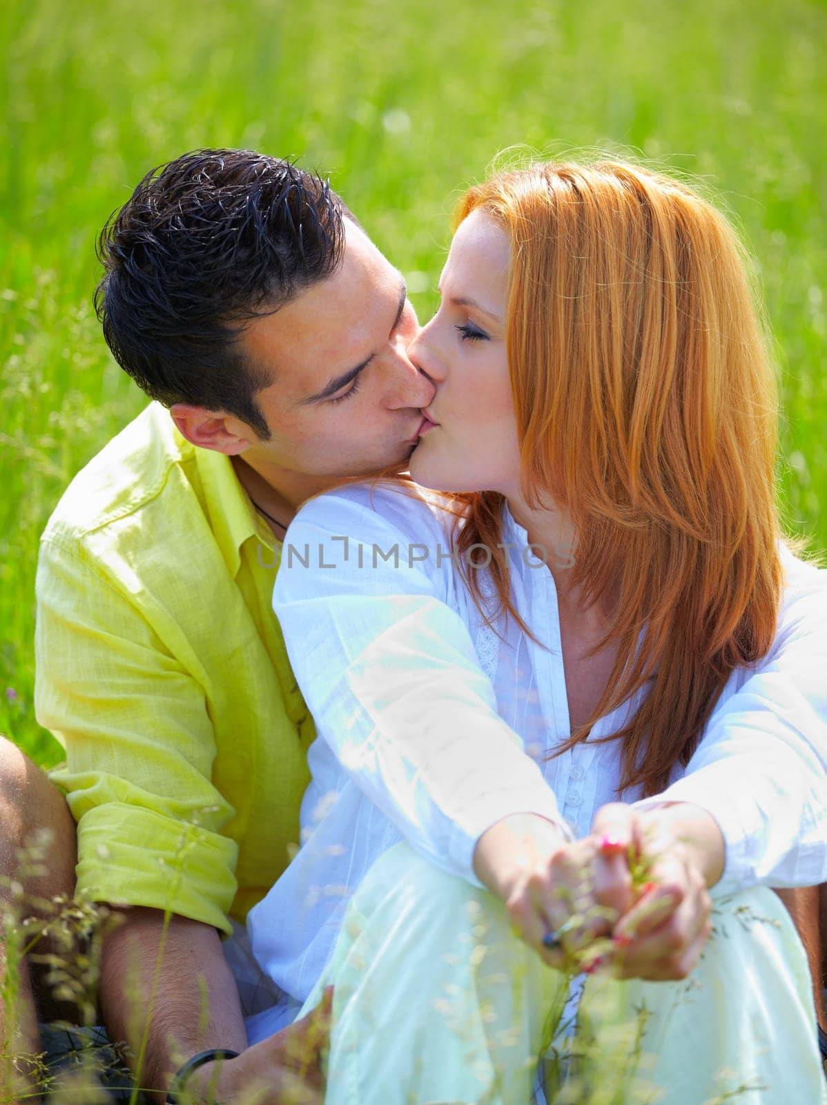 Young couplein their 20s kissing outdoor in summer.
