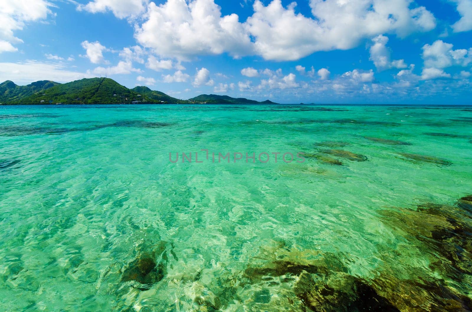 Beautiful turquoise Caribbean sea water with a tropical island in the background