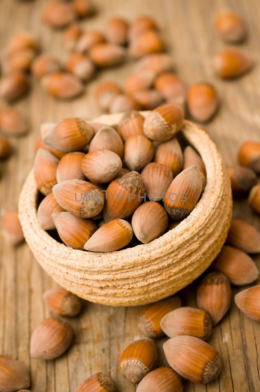Hazelnuts in pot on wooden surface