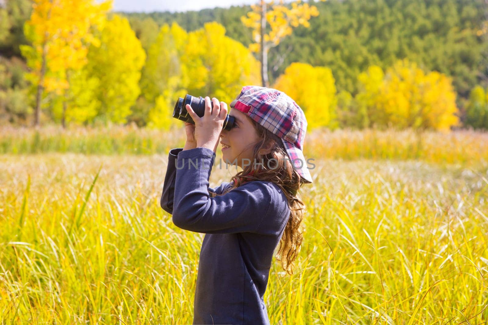 Explorer binocuar looking kid girl in yellow autumn nature outdoor