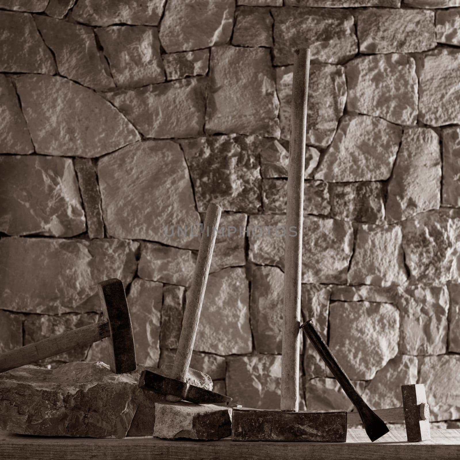 Hammer mason tools of stonecutter masonry work in a contruction stone wall
