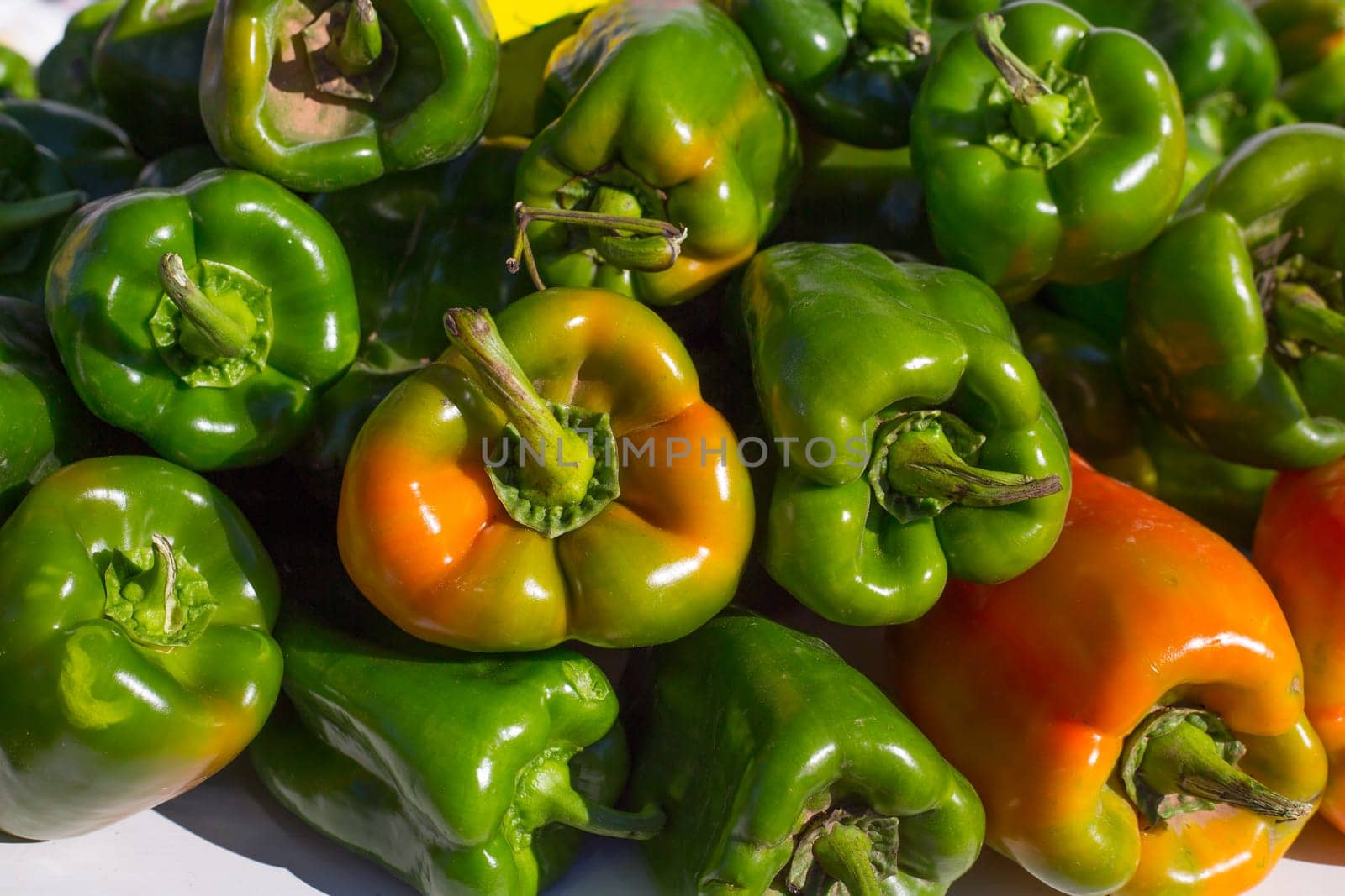 green peppers stacked in a row at market vegetables food