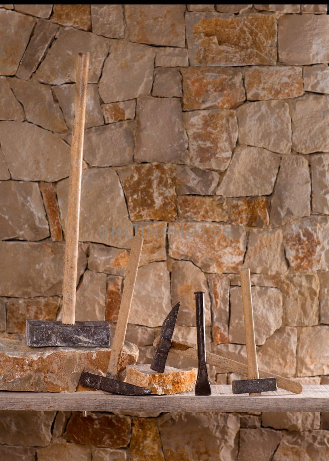 Hammer mason tools of stonecutter masonry work in a contruction stone wall