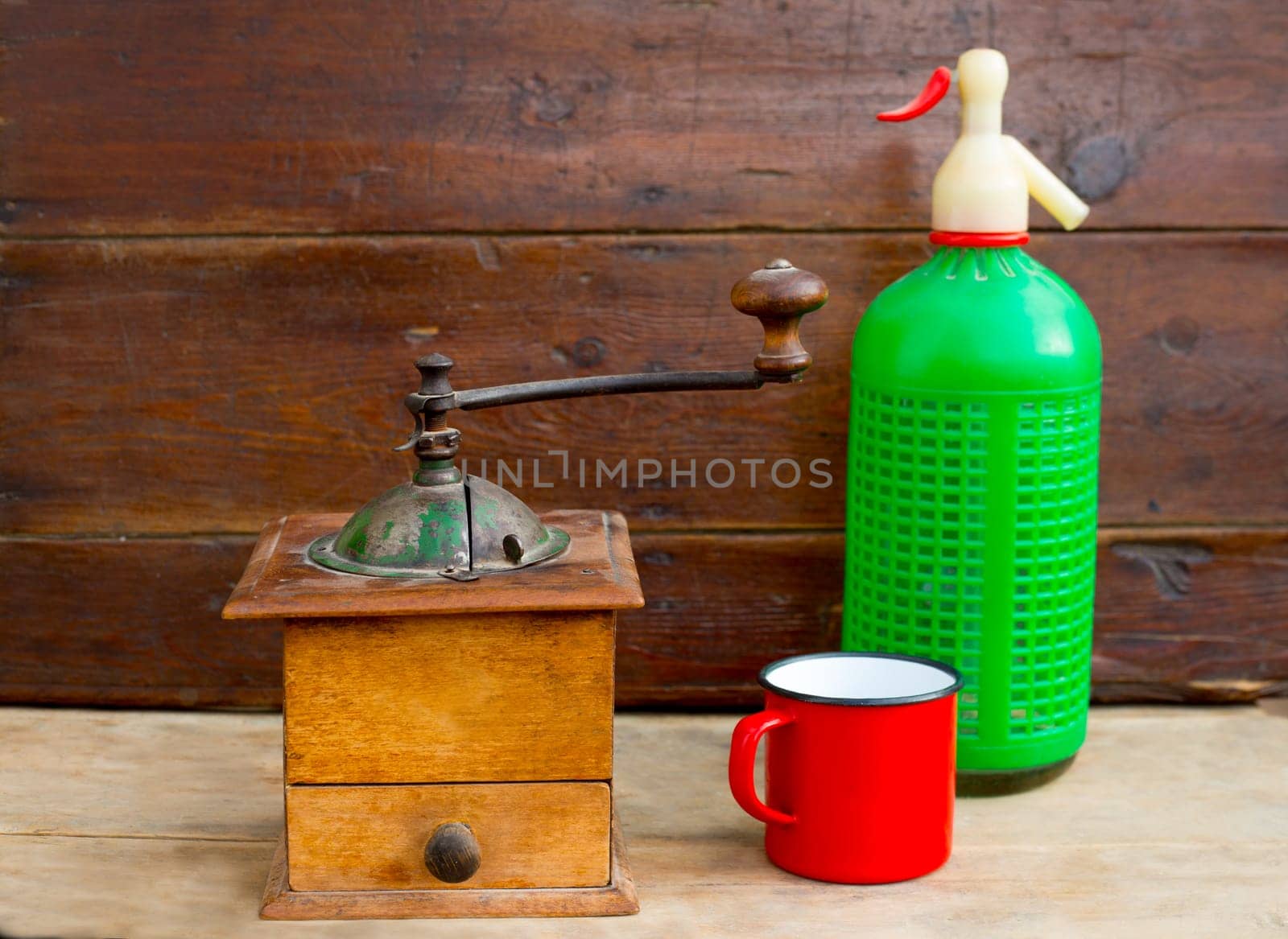 retro old coffee grinder with vintage soda bottle on aged wood