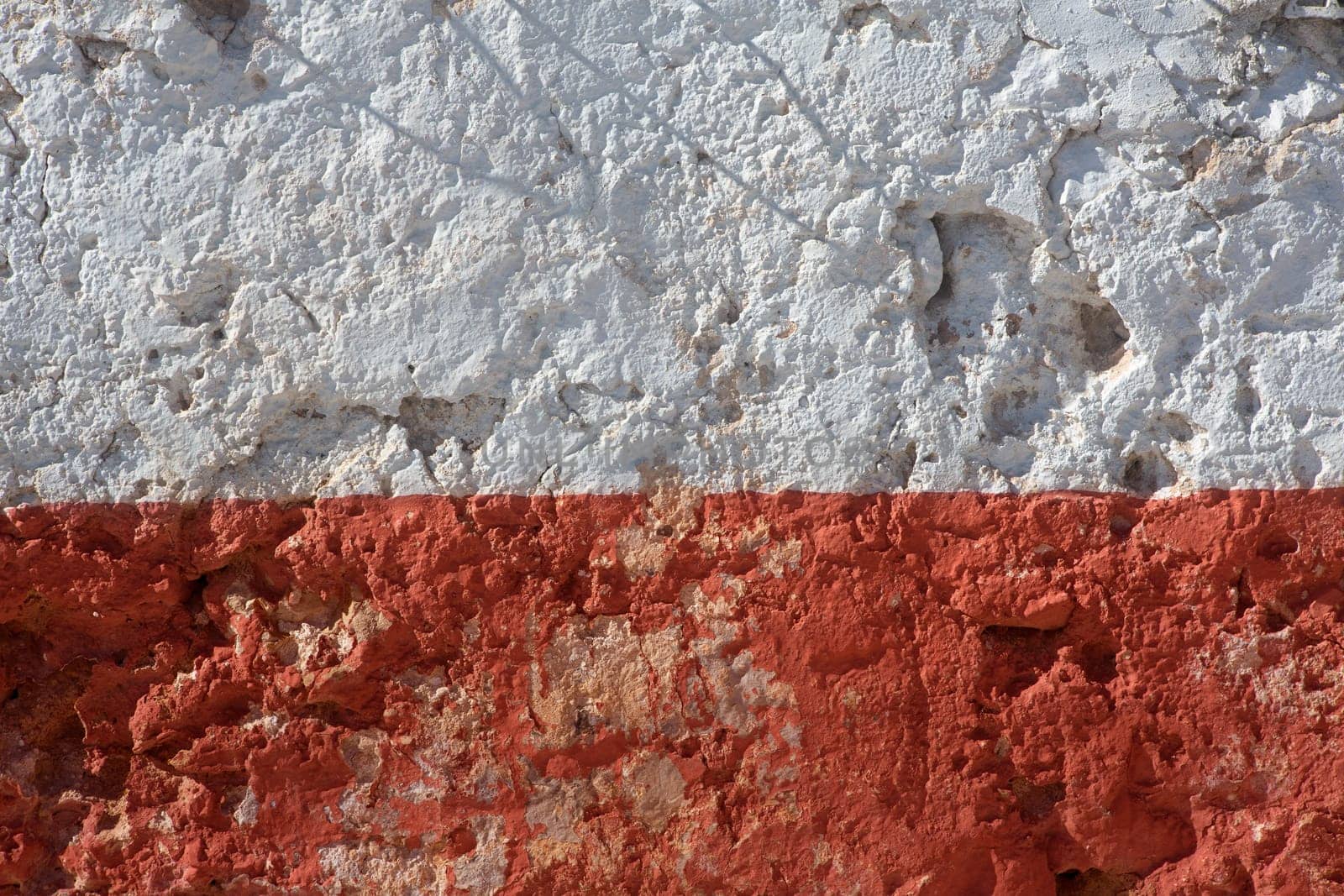 Aged whitewashed wall with red grunge paint wheatered