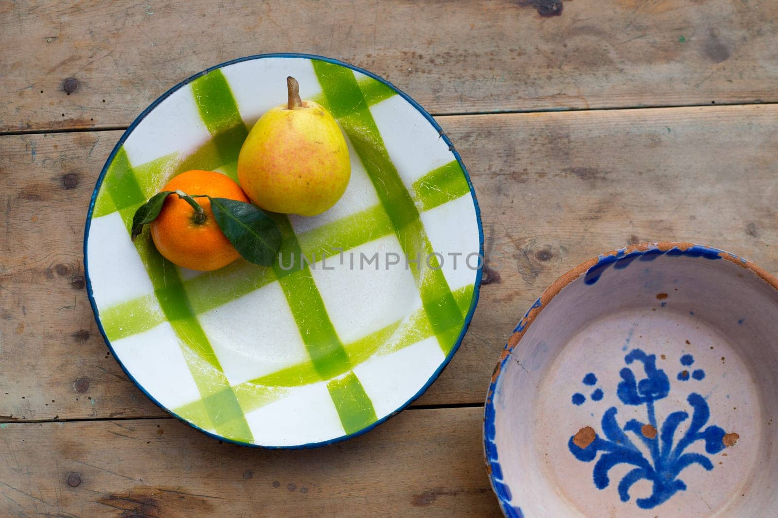 fruits tangerine and pear in vintage porcelain dish plate on retro wood table