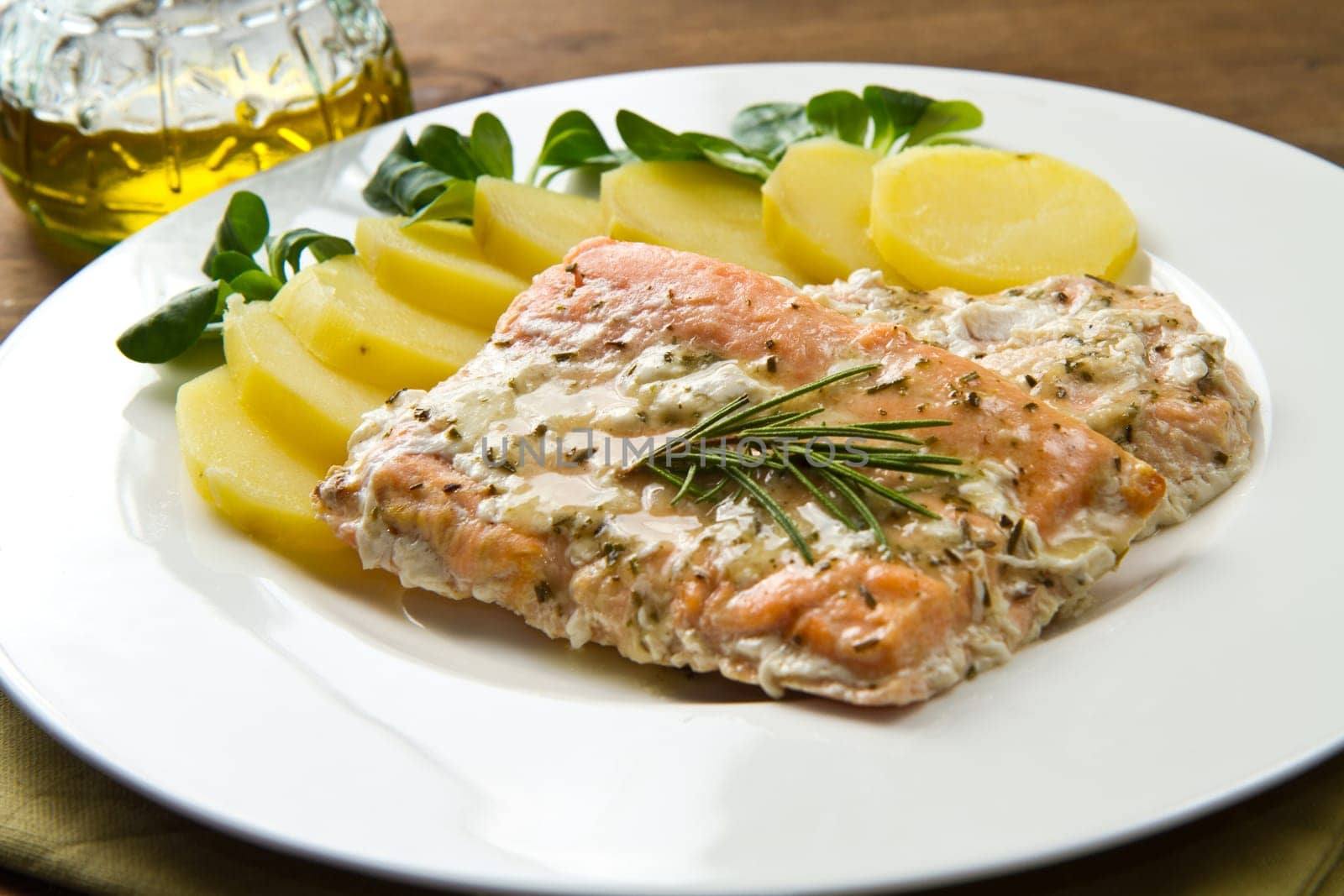 white dish with salmon fillet and potatoes