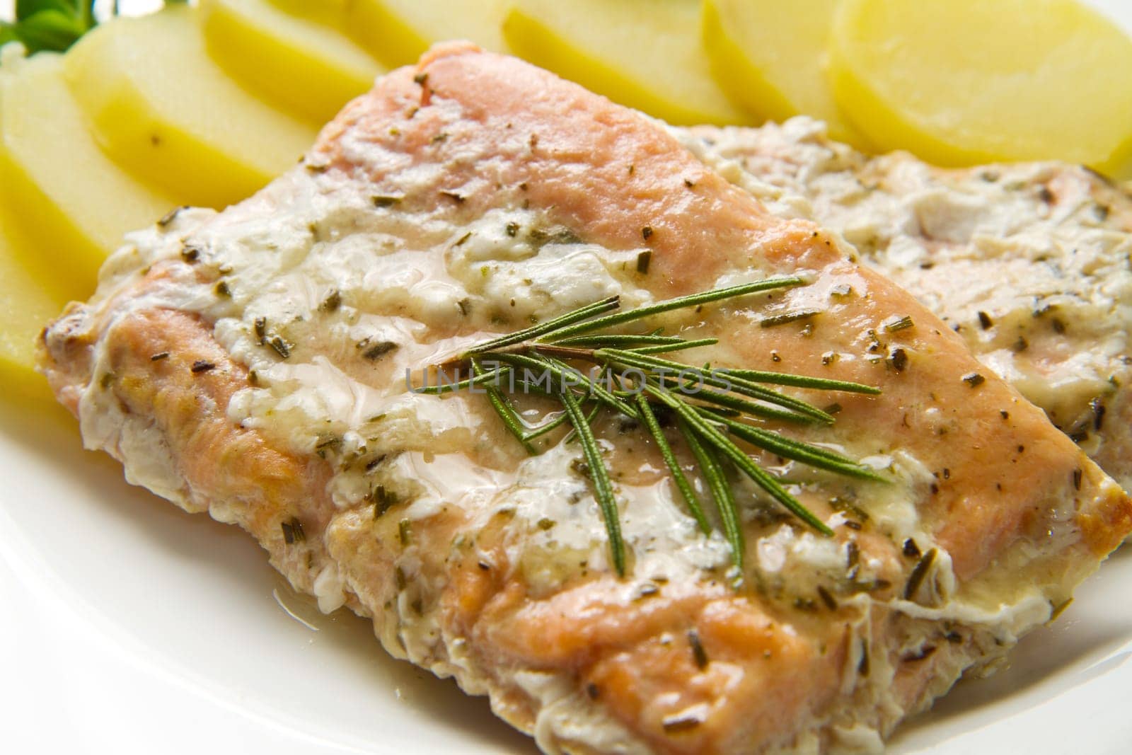 white dish with salmon fillet and potatoes