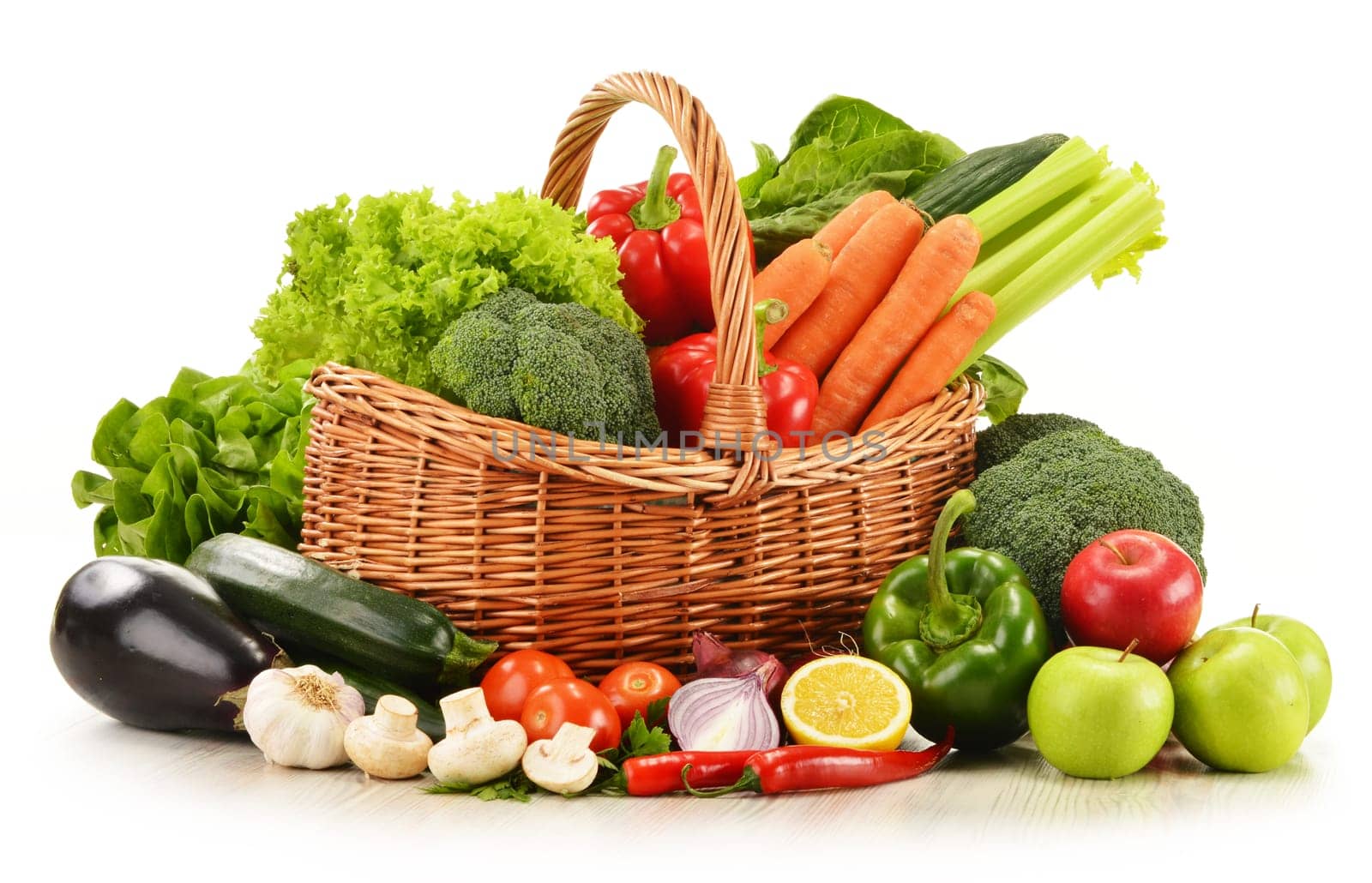 Composition with raw vegetables in wicker basket isolated on white