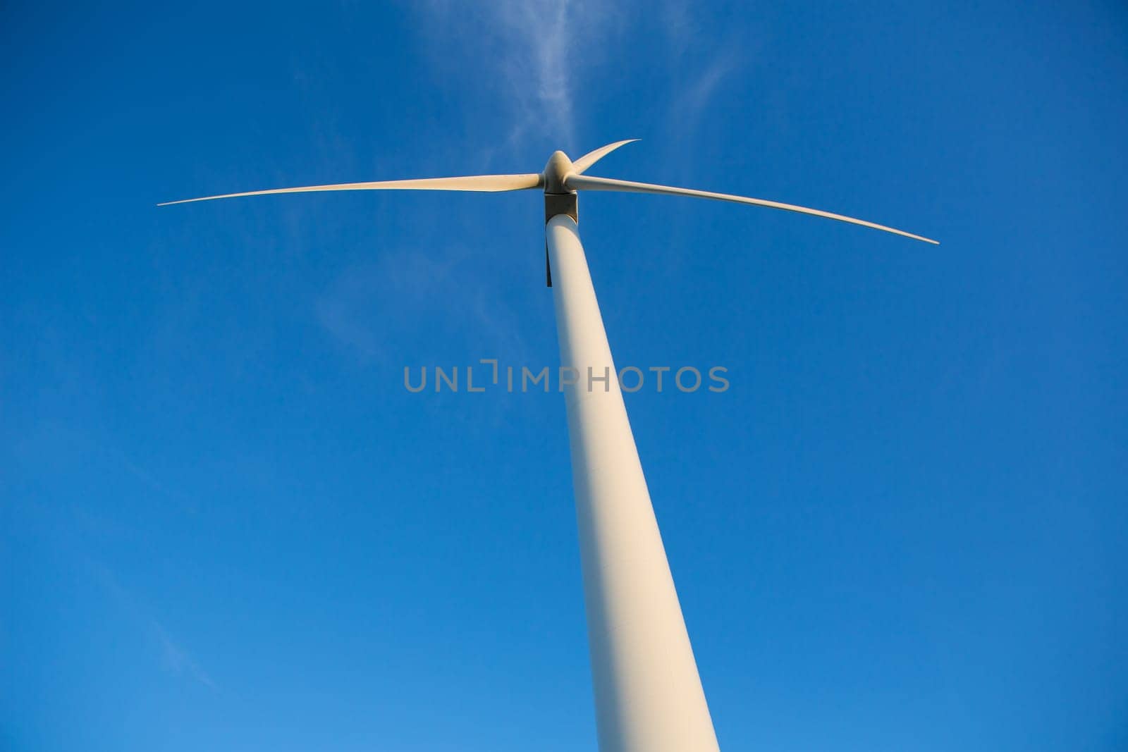 Aerogenerator windmills for green electric energy from below and ble sky background