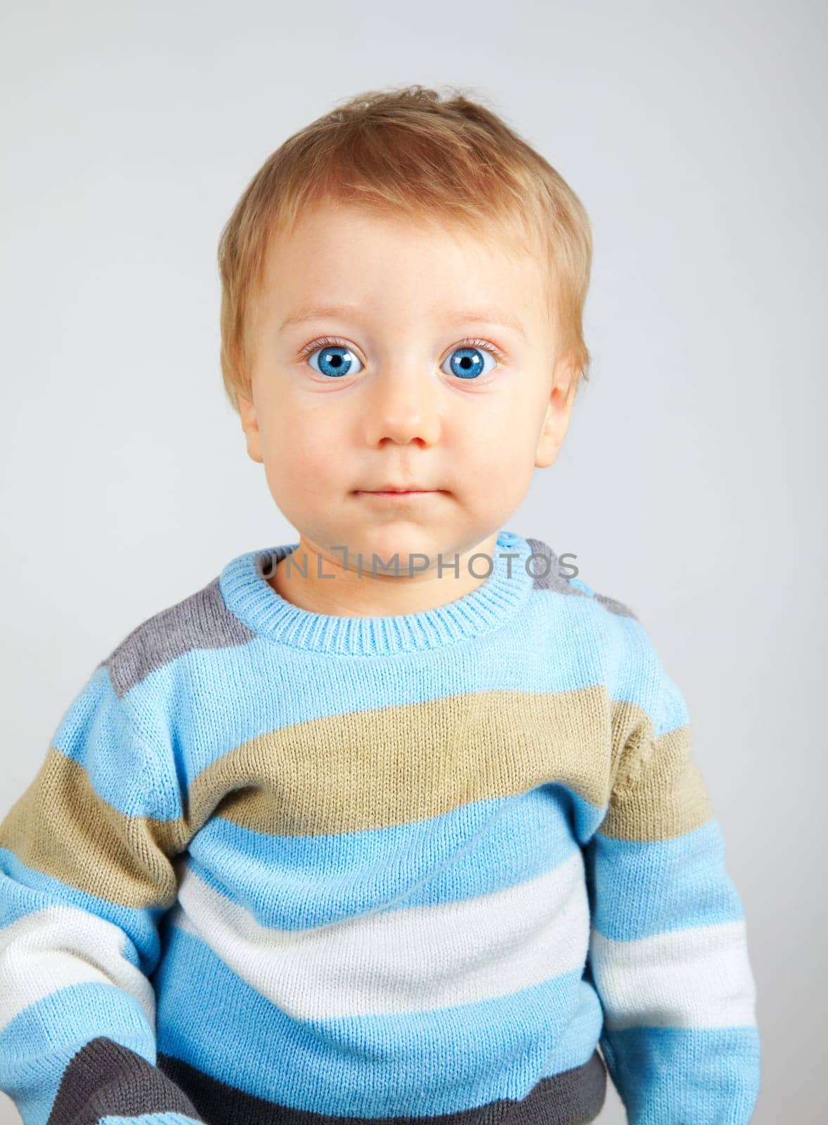 Closeup portrait of a sweet little adorable child over gray background.