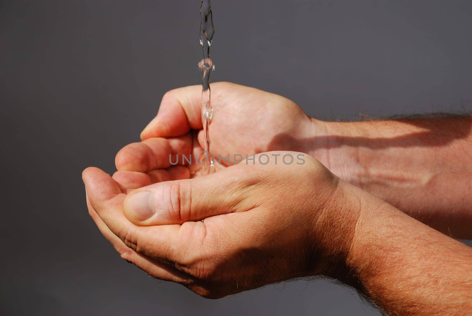 two male hands absorbing clear water