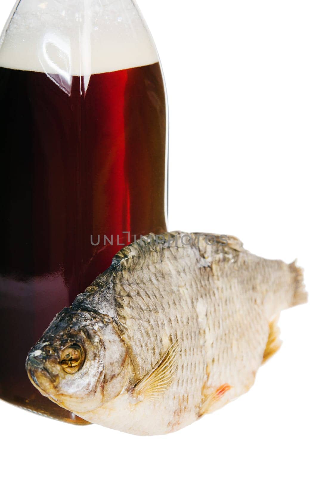 A bottle of domestic beer and dried fish is isolated on white