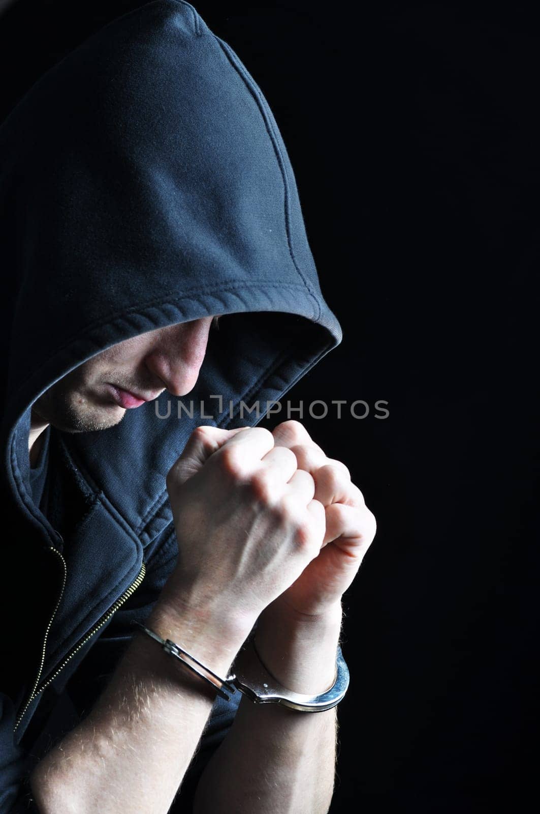 arrested young men with handcuffs on dark background