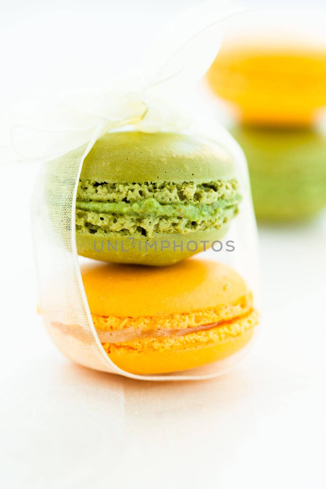 Closeup of yellow and green macaroons against light background