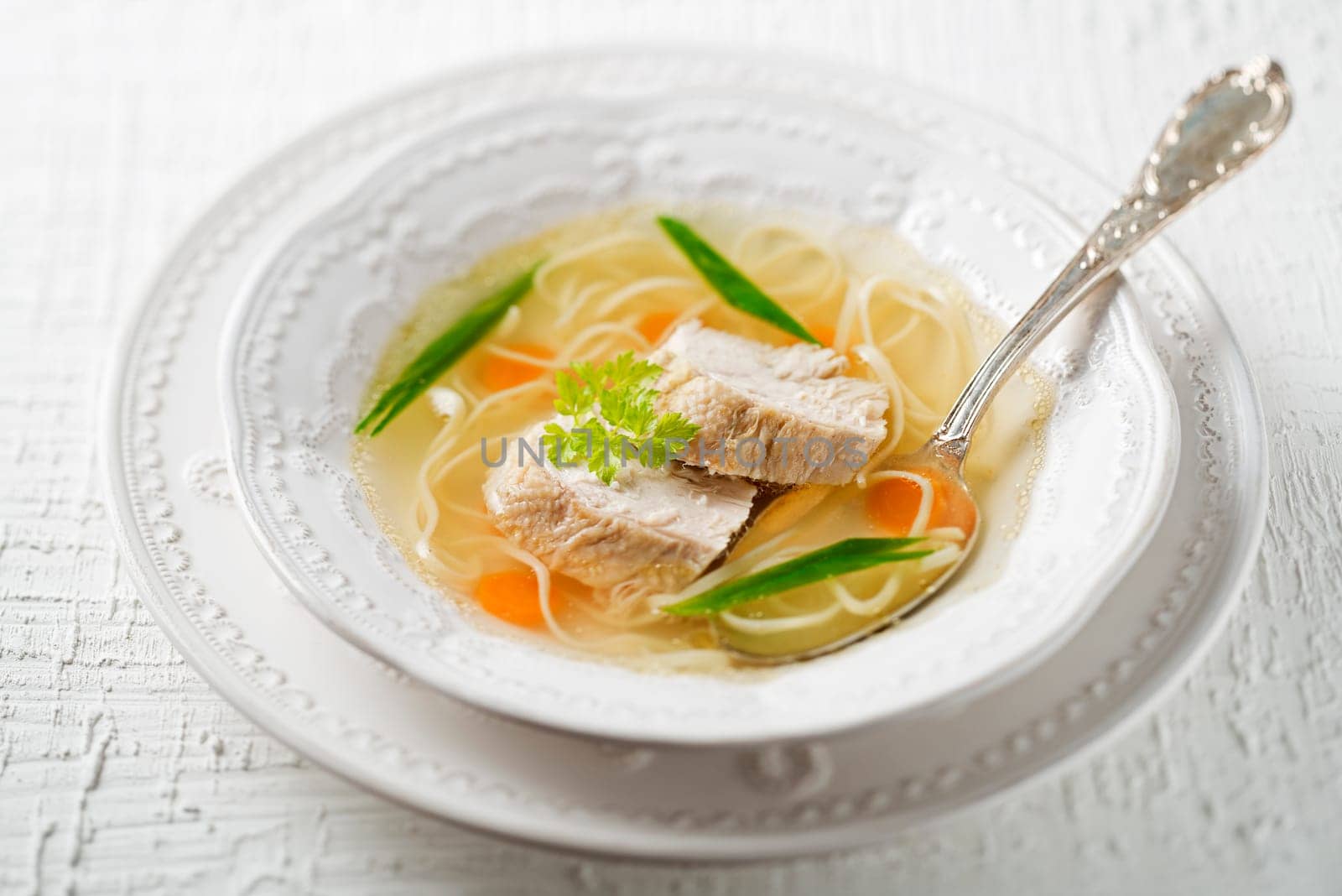 Chicken soup with noodles and meat close up shoot