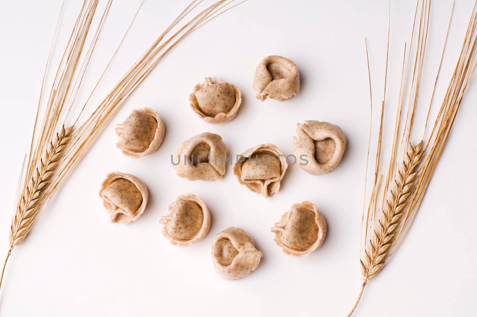 Fresh raw whole grain capeletti isolated on white close up