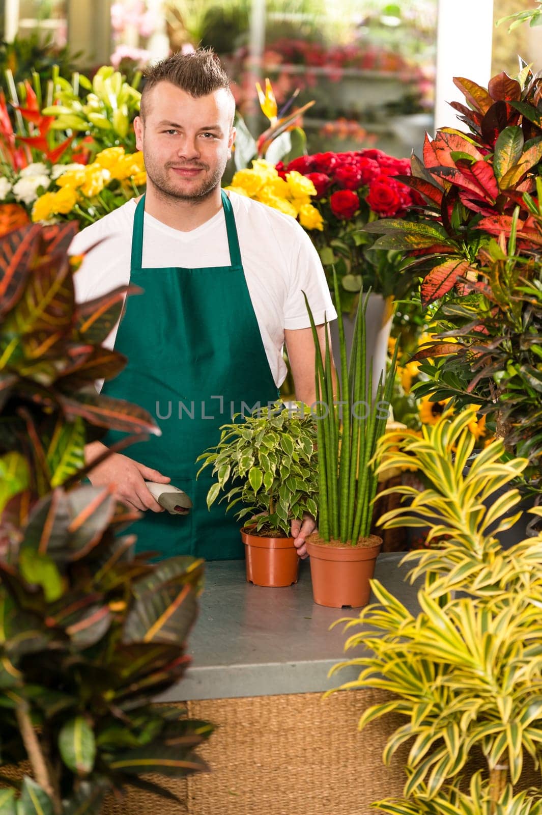 Young man scanning barcode flower shop gardening florist