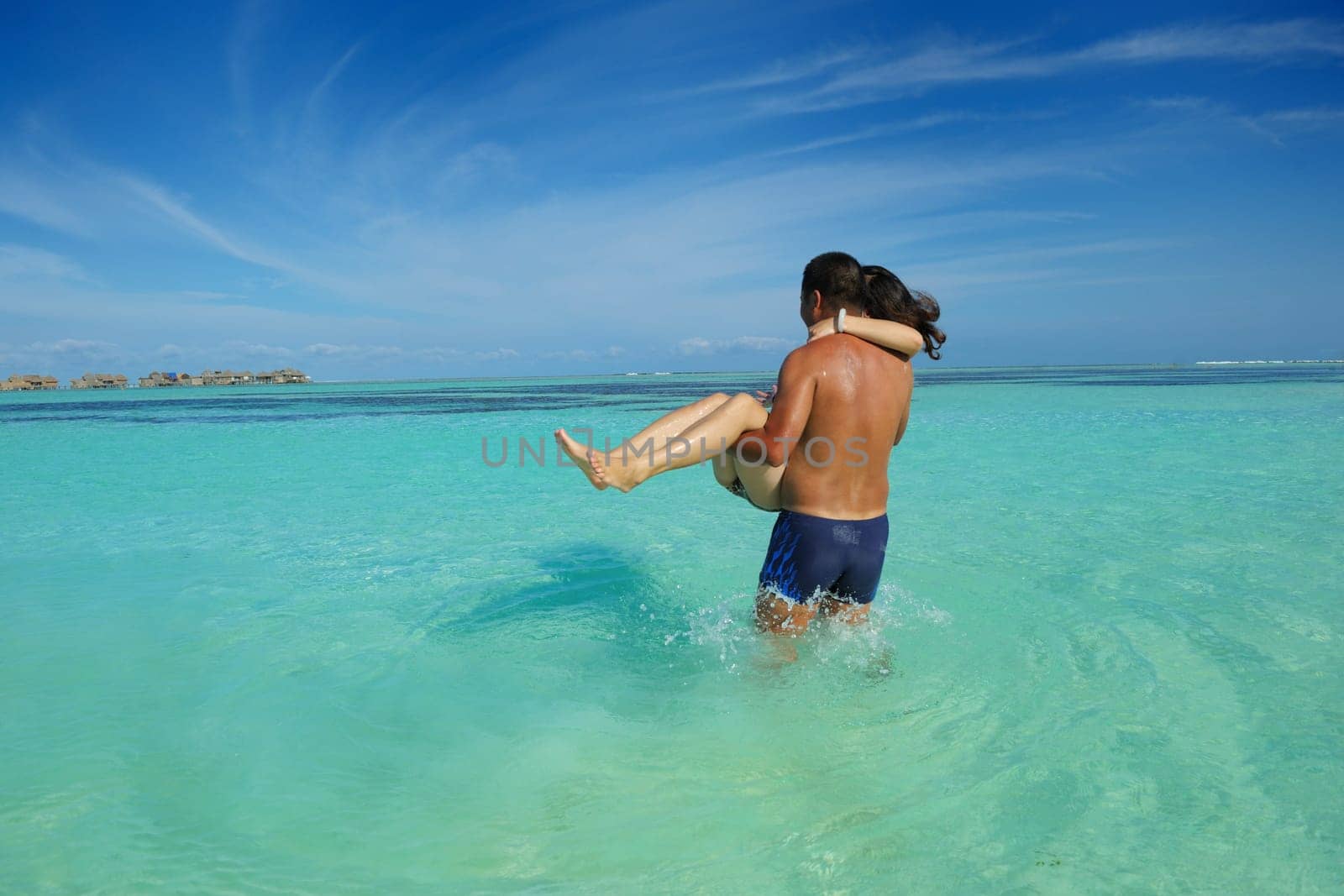 happy young asian couple enjoying summer and have on beautiful white sand beach
