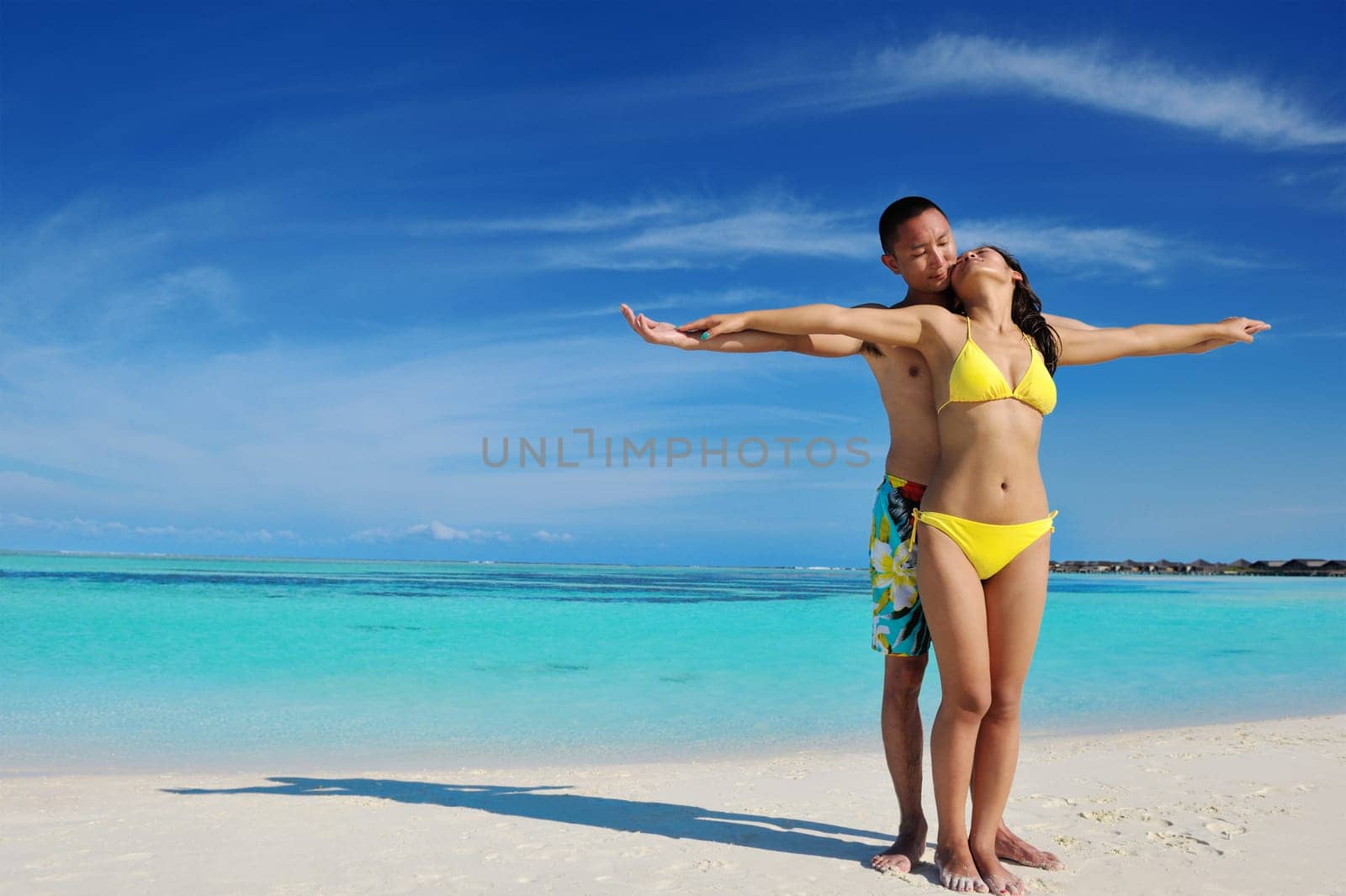 happy young asian couple enjoying summer and have on beautiful white sand beach