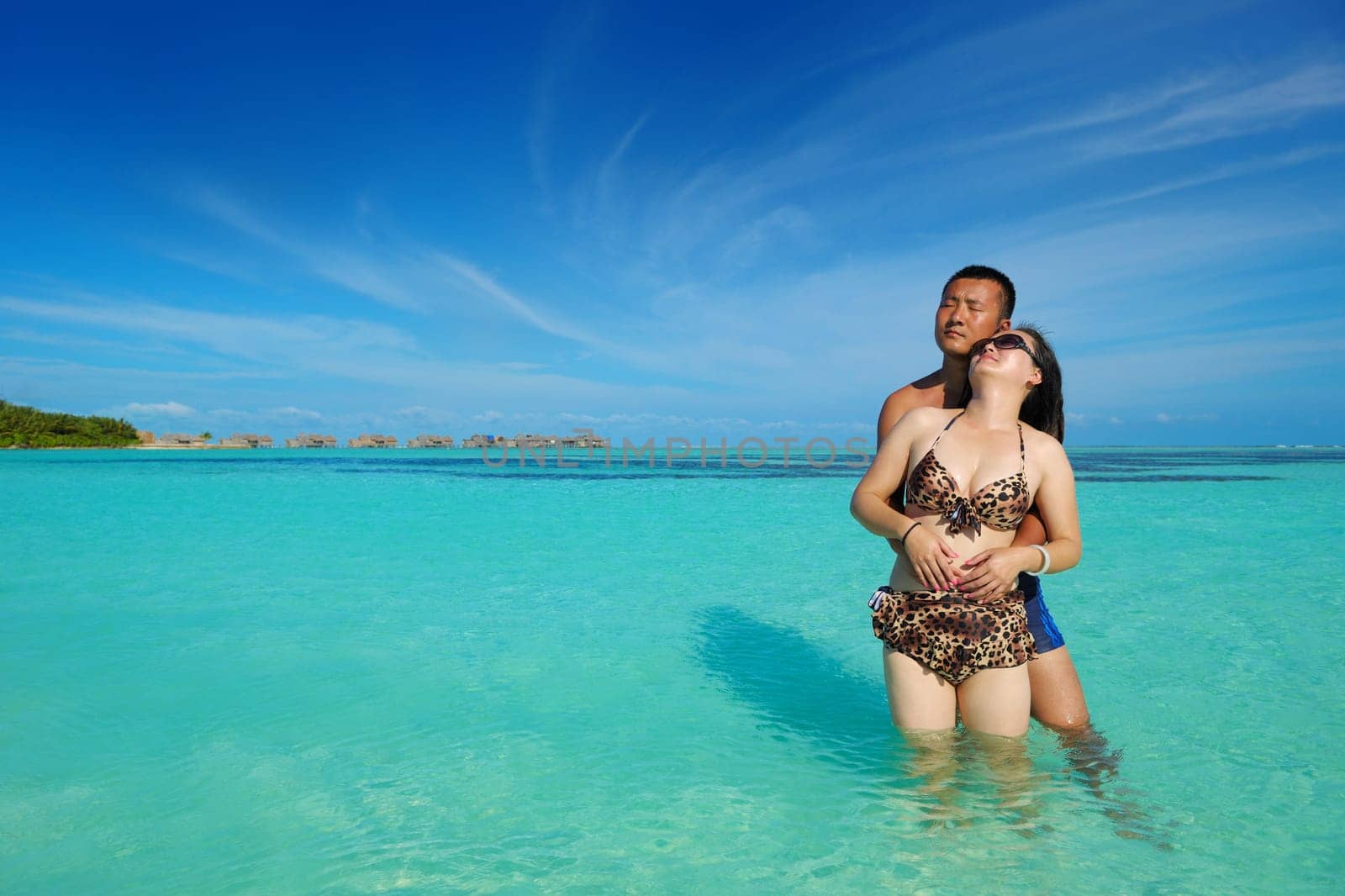 happy young asian couple enjoying summer and have on beautiful white sand beach