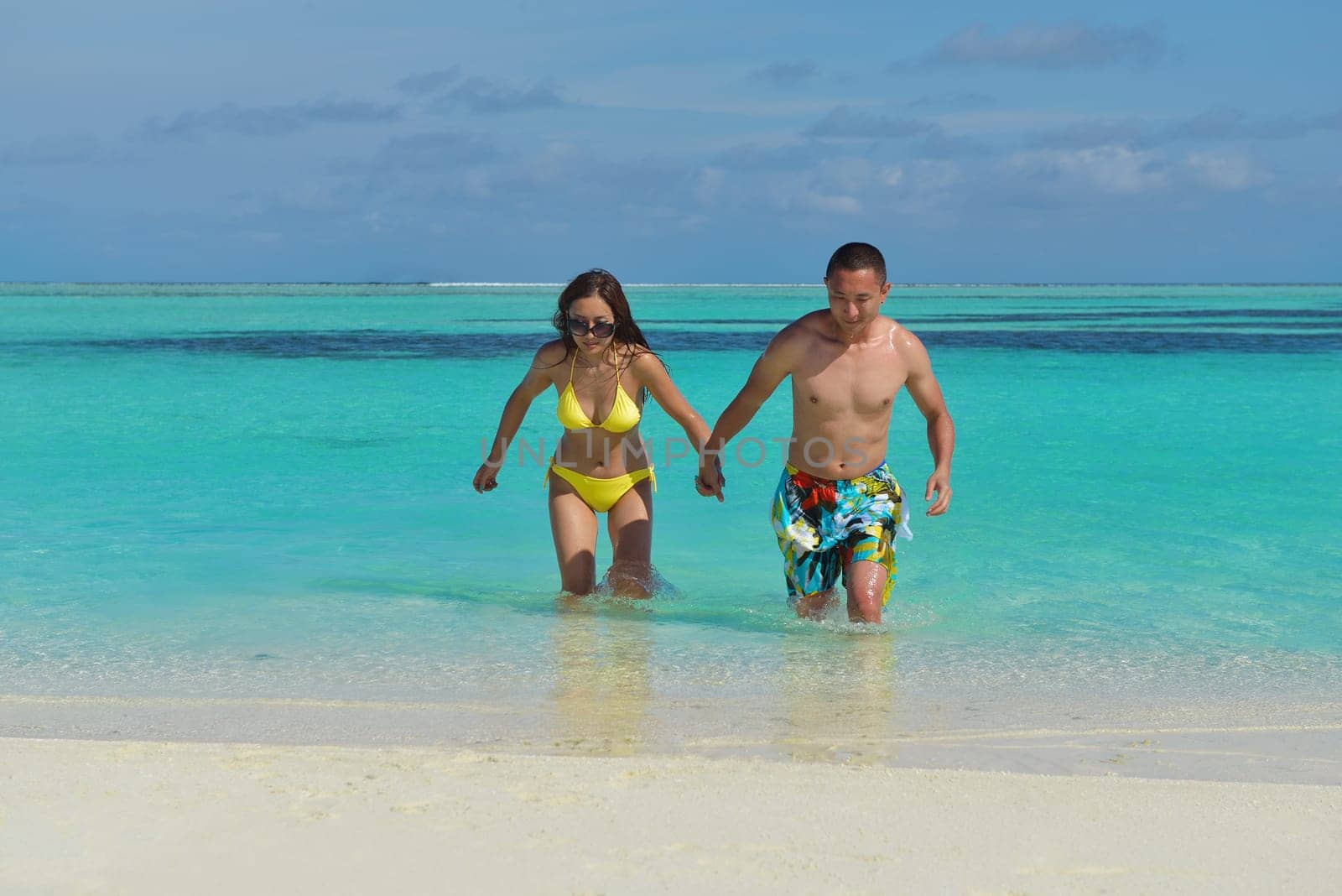 happy young asian couple enjoying summer and have on beautiful white sand beach