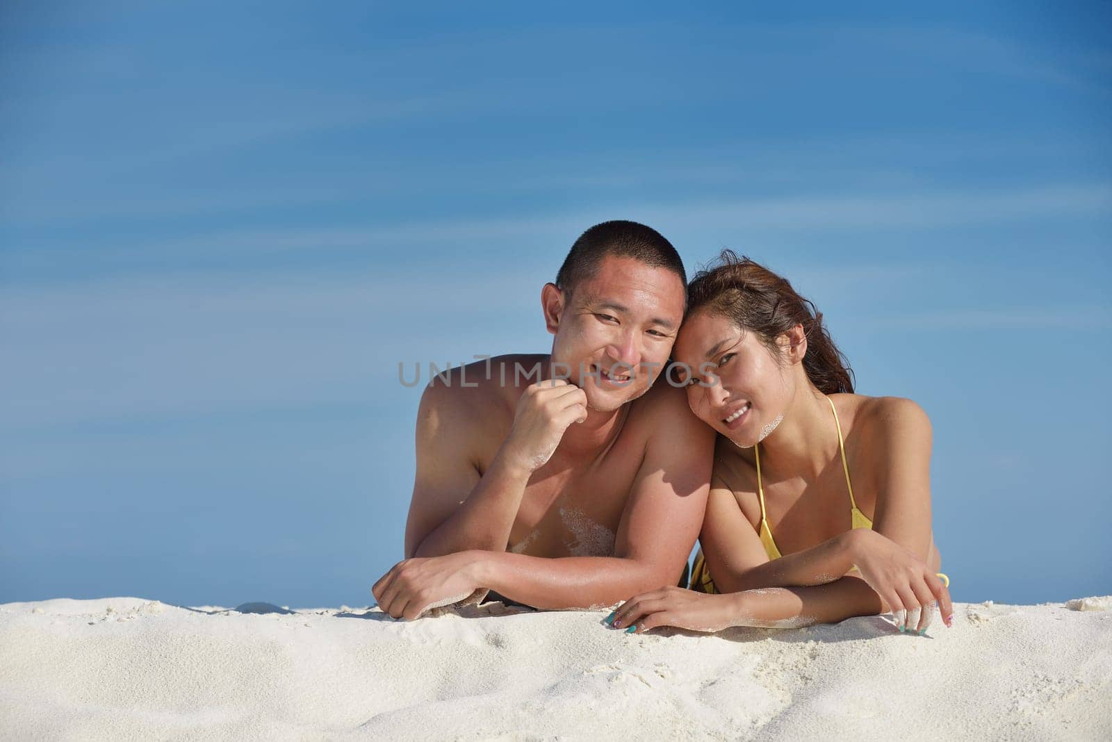 happy young asian couple enjoying summer and have on beautiful white sand beach