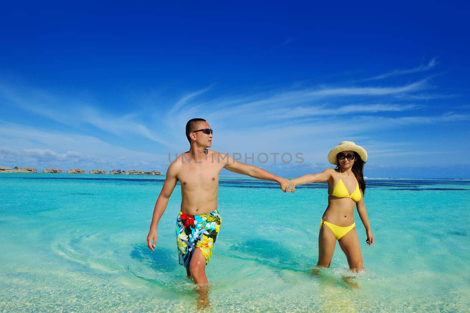 happy young asian couple enjoying summer and have on beautiful white sand beach
