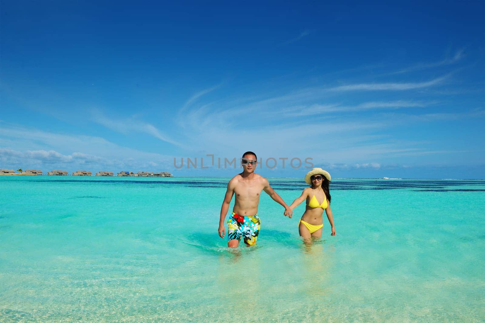 happy young asian couple enjoying summer and have on beautiful white sand beach