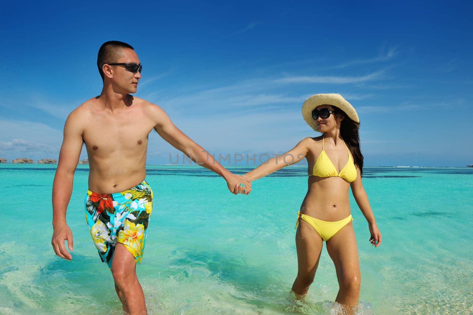 happy young asian couple enjoying summer and have on beautiful white sand beach