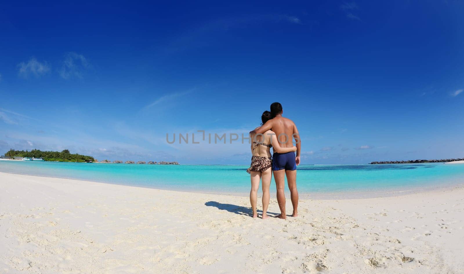 happy young asian couple enjoying summer and have on beautiful white sand beach