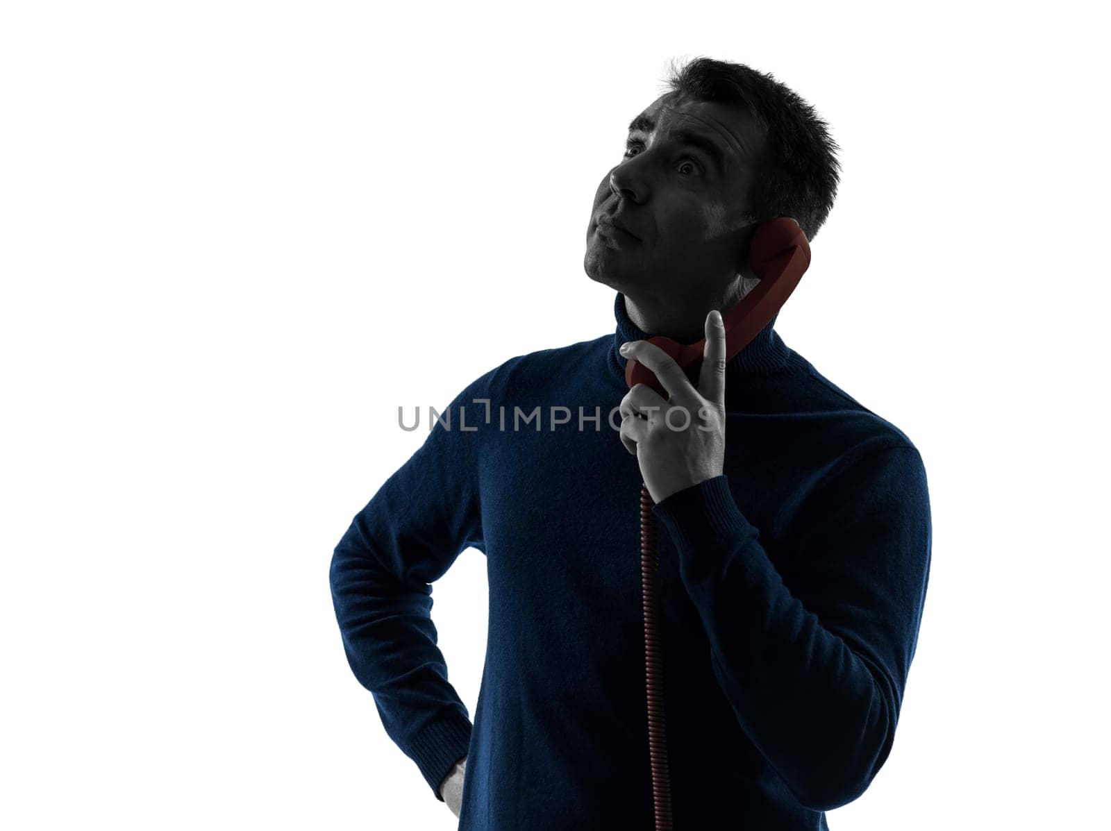 one caucasian man on the phone surprised portrait in silhouette studio isolated on white background