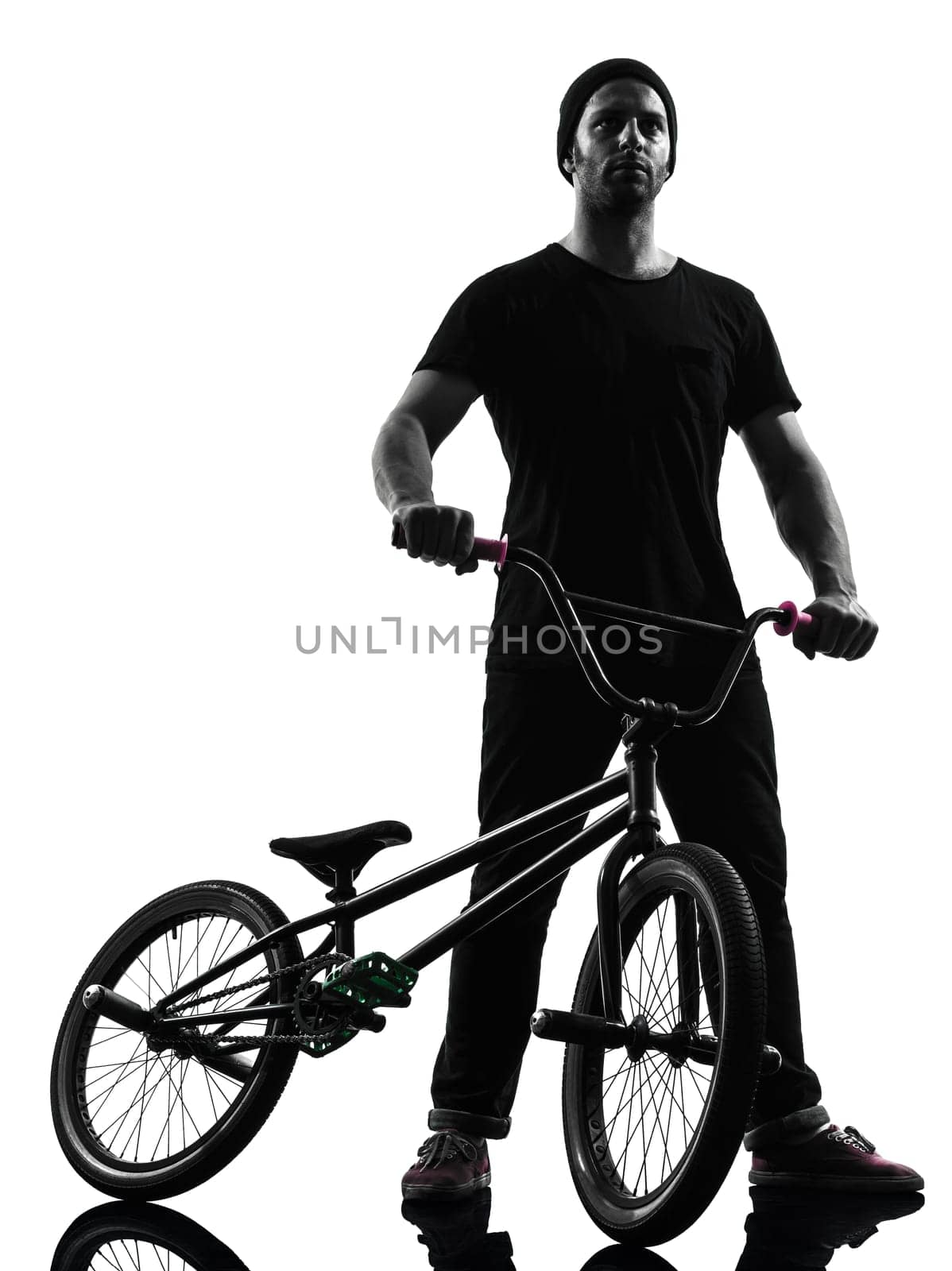 one caucasian man exercising bmx acrobatic figure in silhouette studio isolated on white background
